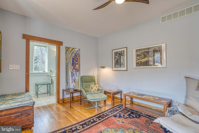 sitting room with baseboards, visible vents, wood-type flooring, and ceiling fan