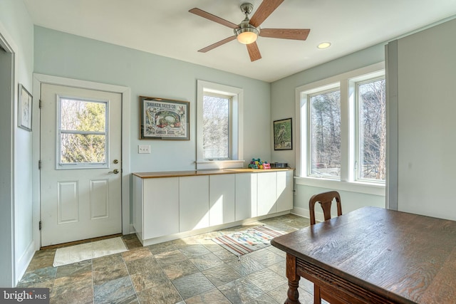 interior space with ceiling fan, recessed lighting, baseboards, and stone finish flooring