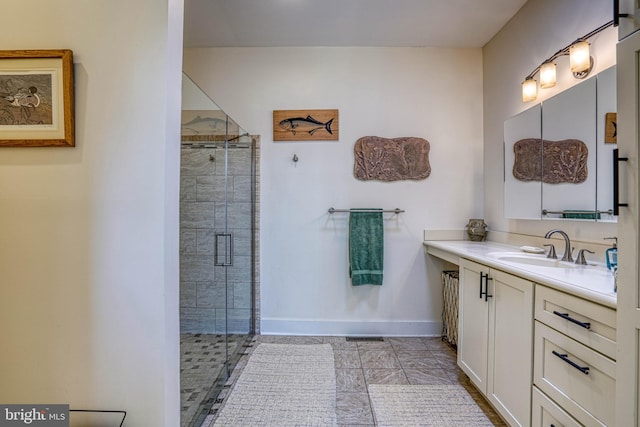 full bathroom featuring baseboards, a shower stall, and vanity