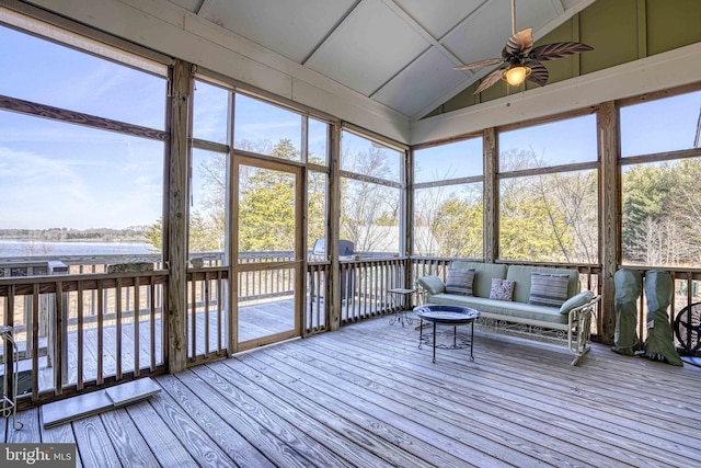 sunroom featuring a water view, ceiling fan, and vaulted ceiling