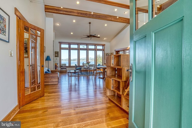 entrance foyer featuring french doors, beam ceiling, high vaulted ceiling, and wood finished floors