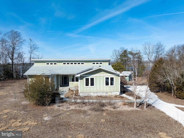 view of front facade with roof with shingles and board and batten siding