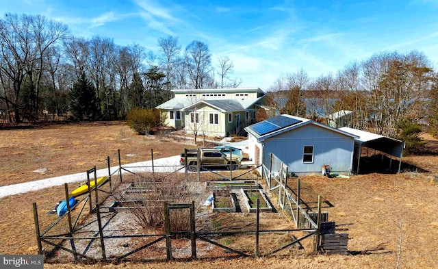 back of house featuring a vegetable garden and fence