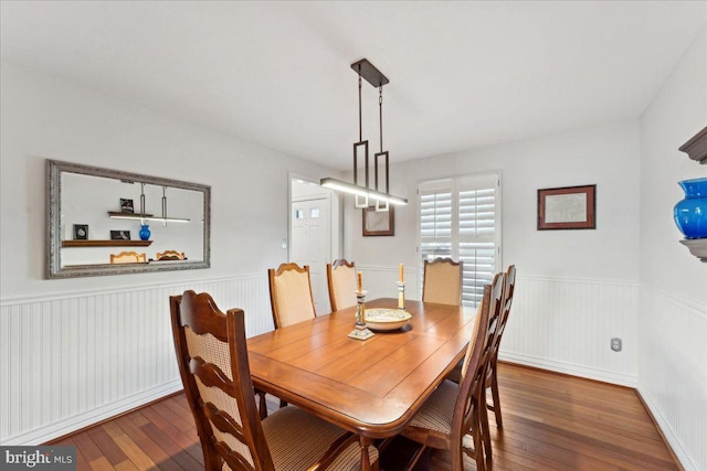 dining area featuring hardwood / wood-style flooring and a wainscoted wall