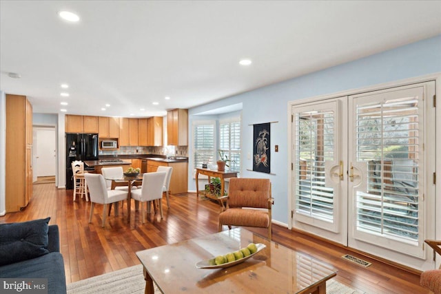 living room with visible vents, recessed lighting, french doors, and hardwood / wood-style floors