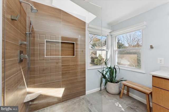 full bath with baseboards, walk in shower, and vanity