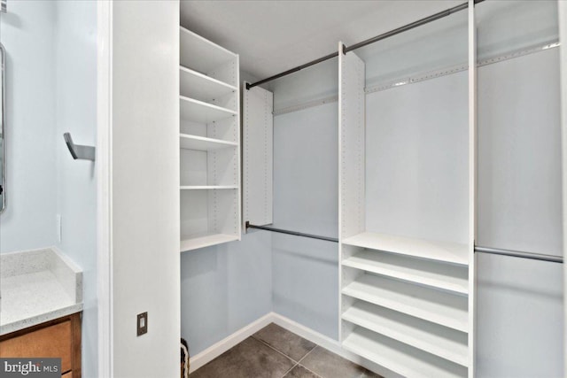 spacious closet featuring dark tile patterned flooring