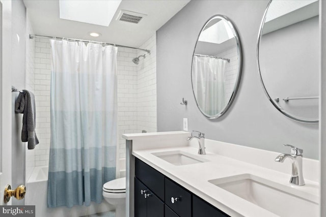 full bath featuring a sink, visible vents, shower / bath combo with shower curtain, and toilet