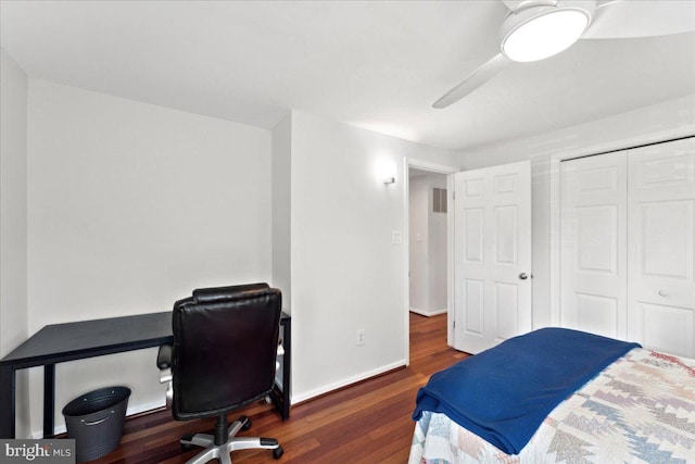 bedroom with visible vents, wood finished floors, a closet, baseboards, and ceiling fan