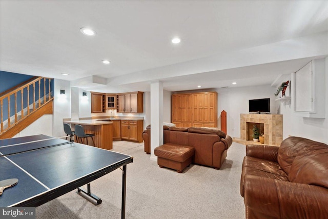 game room with a tiled fireplace, recessed lighting, and light colored carpet