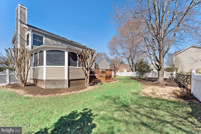 view of yard with a deck, a fenced backyard, and a sunroom