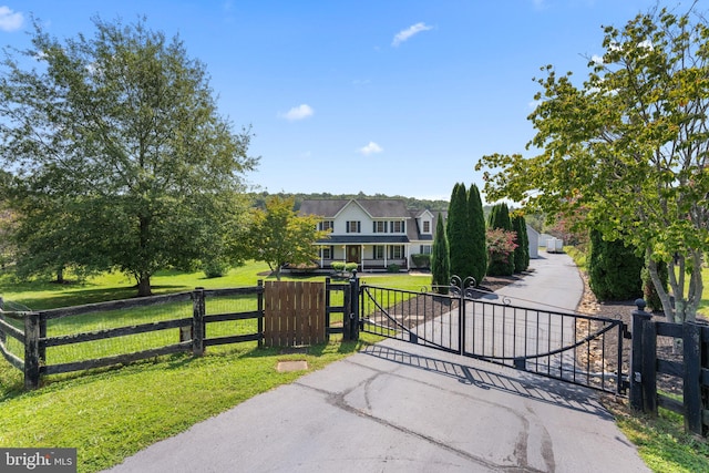 view of gate with fence and a lawn