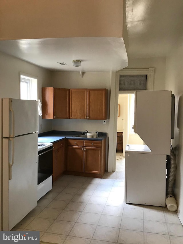 kitchen featuring white fridge, sink, and electric range oven