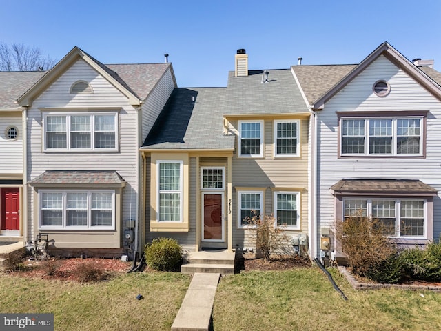 view of front of property with a chimney and a front lawn