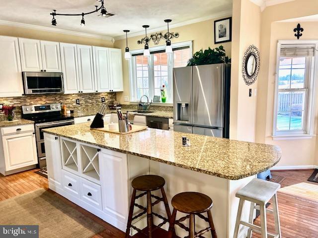 kitchen with white cabinetry, stainless steel appliances, and a kitchen island