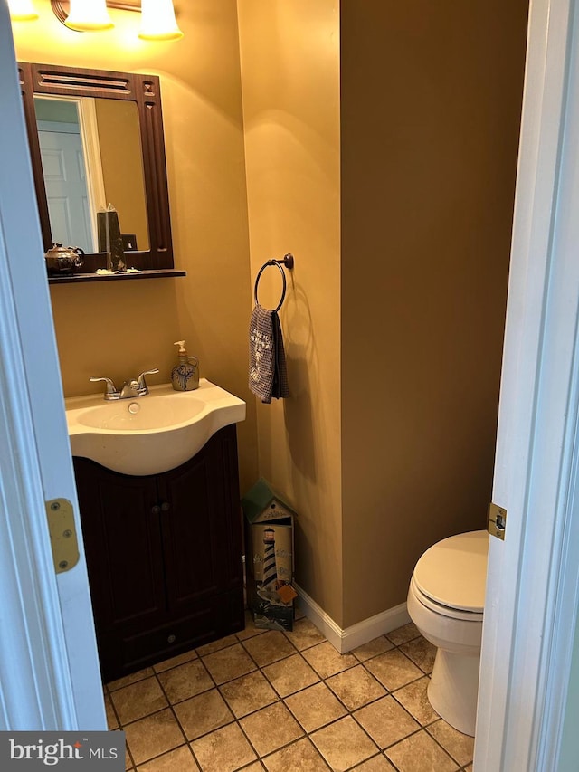 bathroom featuring toilet, tile patterned flooring, and vanity