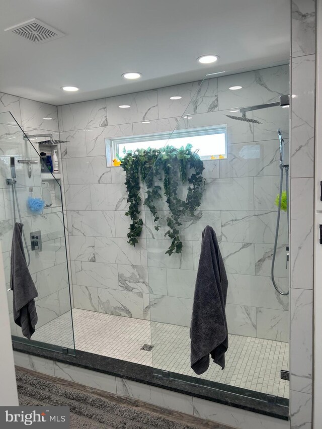 bathroom featuring a shower with door