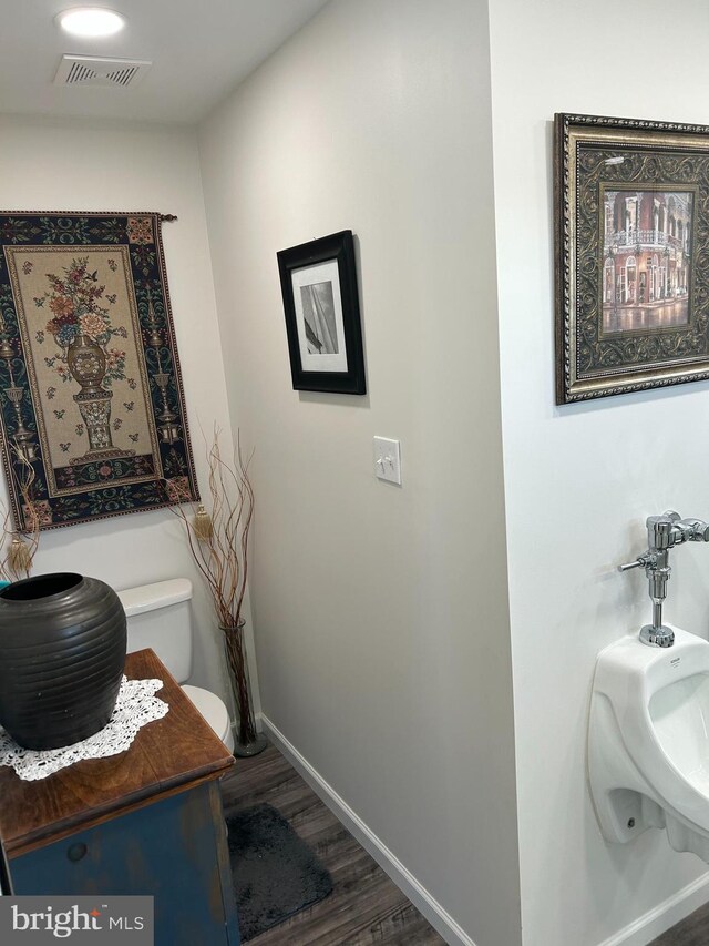 interior space with toilet and wood-type flooring