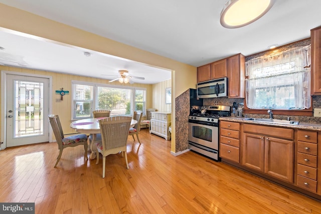 kitchen featuring light hardwood / wood-style flooring, stainless steel appliances, ceiling fan, backsplash, and sink