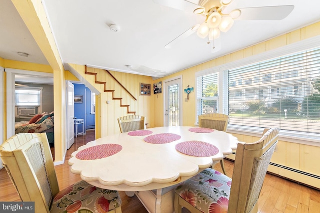 dining space with cooling unit, light wood-type flooring, and ceiling fan