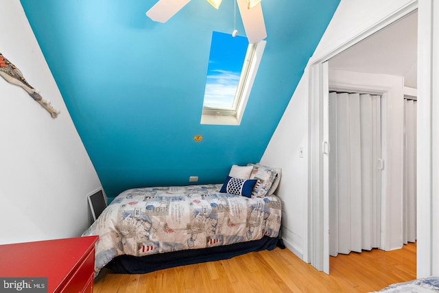 bedroom featuring ceiling fan, wood-type flooring, and a skylight