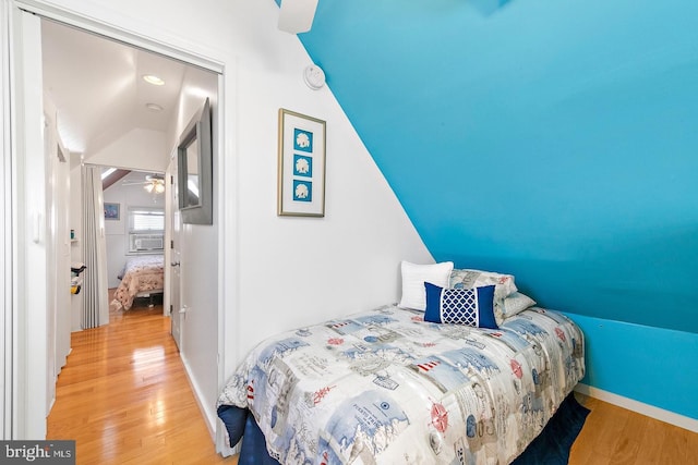 bedroom with hardwood / wood-style flooring and lofted ceiling