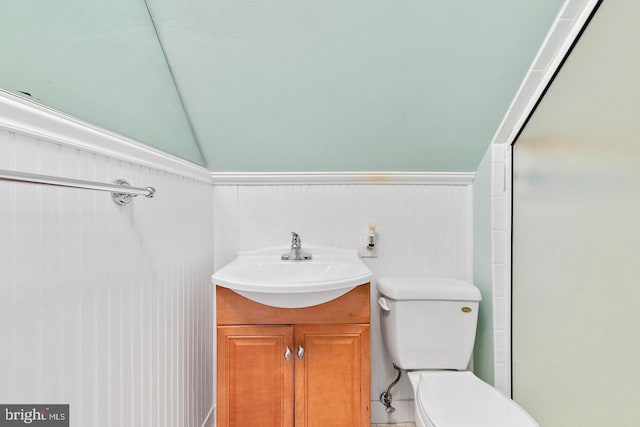 bathroom featuring toilet, vanity, and lofted ceiling