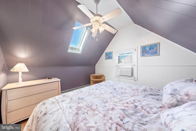 bedroom featuring cooling unit, vaulted ceiling with skylight, baseboard heating, and ceiling fan