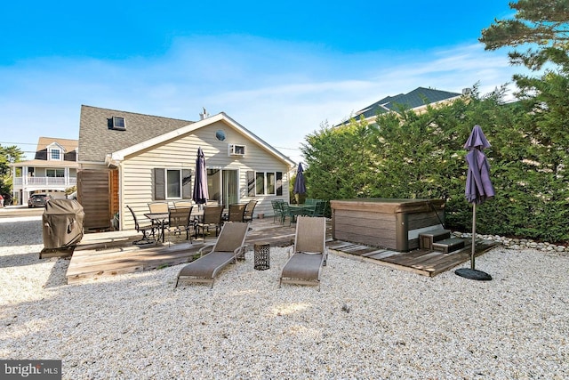 rear view of property featuring a hot tub