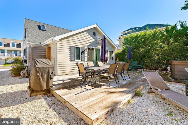 wooden deck featuring area for grilling and a hot tub