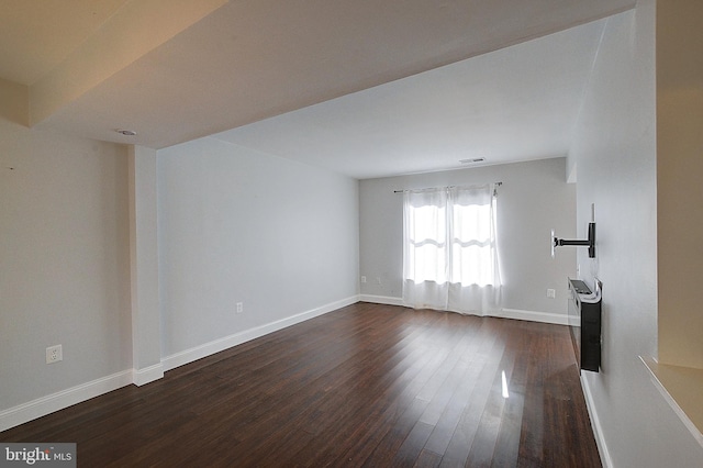 unfurnished living room with dark wood finished floors and baseboards