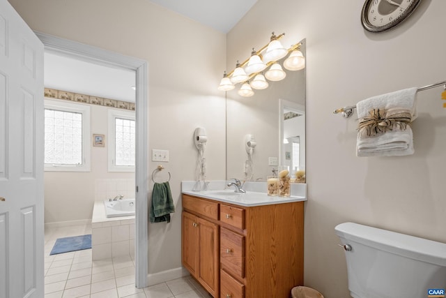 bathroom featuring toilet, vanity, tile patterned flooring, and tiled tub