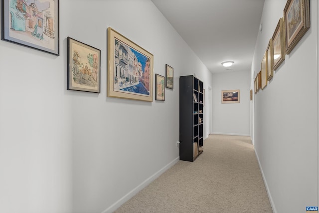 hallway featuring light colored carpet