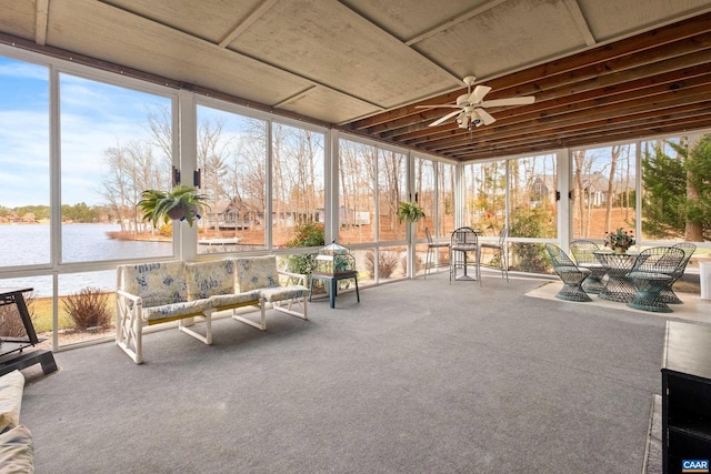 sunroom / solarium with a water view and ceiling fan