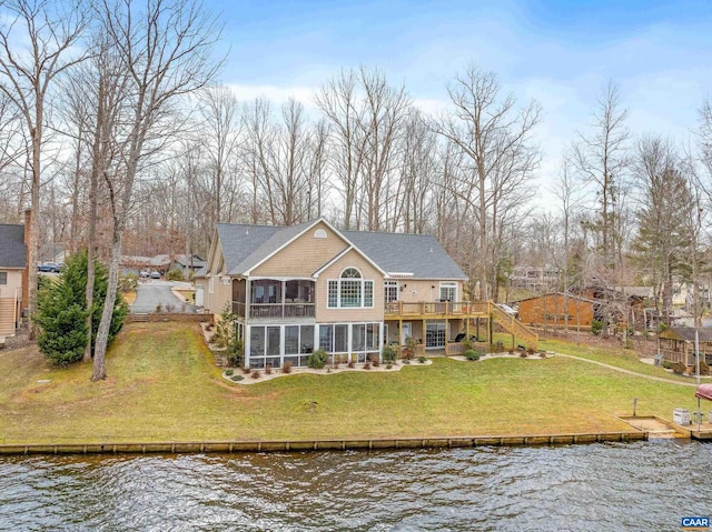 rear view of house with a lawn, a water view, and a sunroom