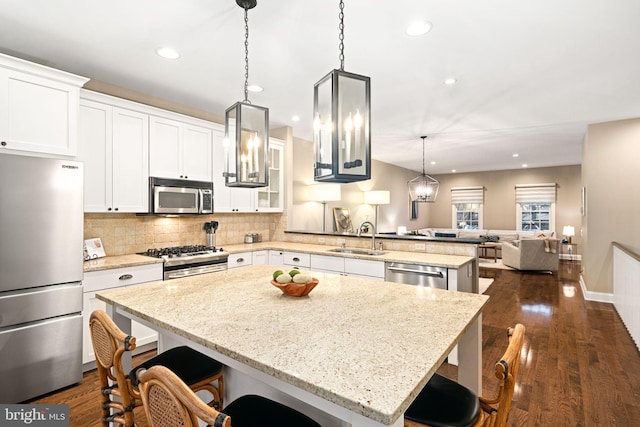 kitchen featuring sink, appliances with stainless steel finishes, a kitchen island, and a kitchen breakfast bar