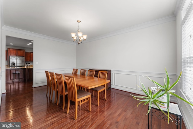 dining space featuring dark hardwood / wood-style floors, crown molding, and a chandelier