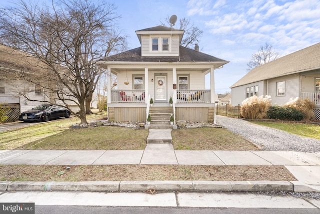 bungalow-style home featuring a chimney, a front lawn, and a porch