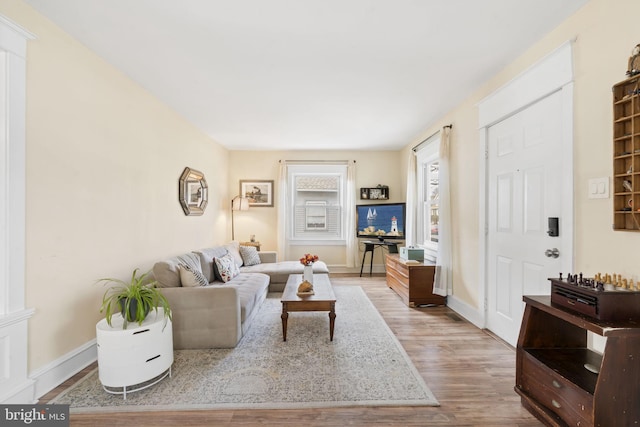 living area with baseboards and wood finished floors