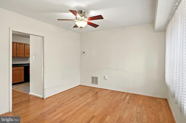 spare room with light wood-type flooring and ceiling fan