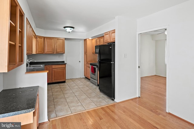 kitchen featuring light hardwood / wood-style floors, electric stove, sink, ceiling fan, and black fridge