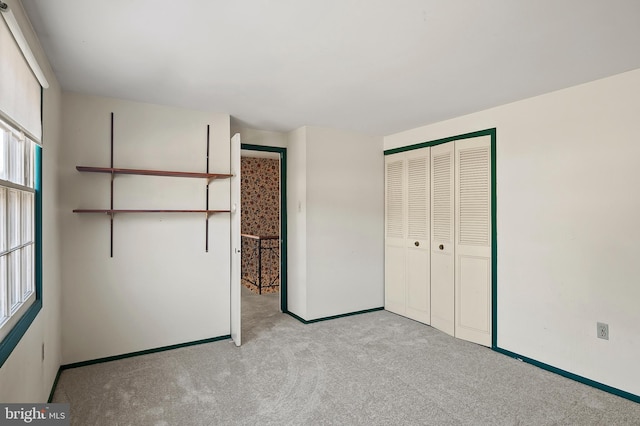 unfurnished bedroom with a closet and light carpet