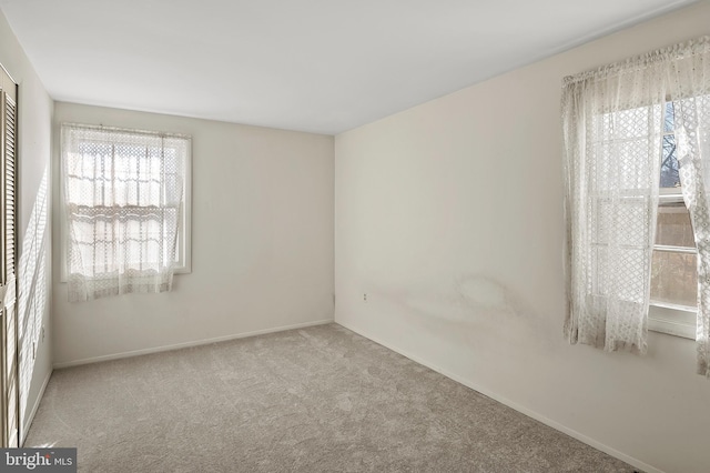 carpeted spare room featuring plenty of natural light