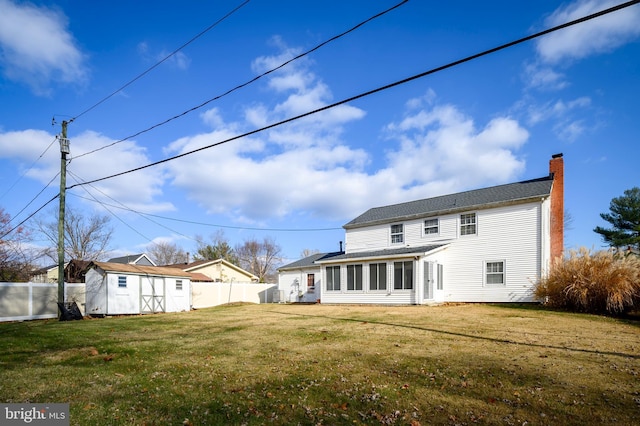 back of house featuring a yard and a storage shed