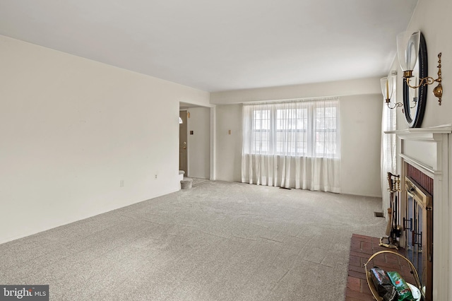 unfurnished living room with a brick fireplace and light colored carpet