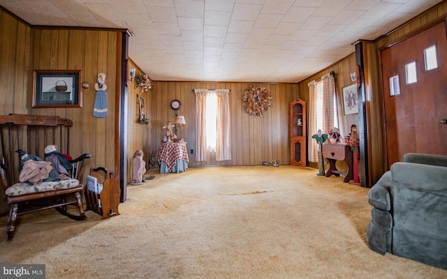 living room with plenty of natural light, carpet floors, and wood walls