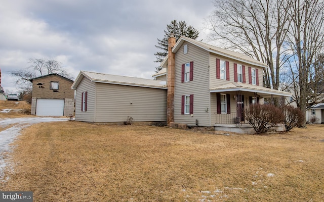 view of front of property with an outbuilding, a front yard, a garage, and a porch