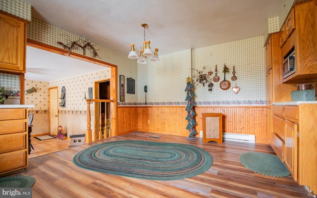 kitchen featuring a baseboard radiator, hardwood / wood-style flooring, hanging light fixtures, and a notable chandelier