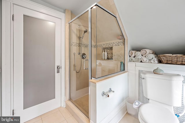 bathroom featuring a stall shower, toilet, and tile patterned floors