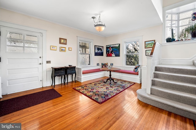 foyer featuring stairs, ornamental molding, plenty of natural light, and hardwood / wood-style flooring